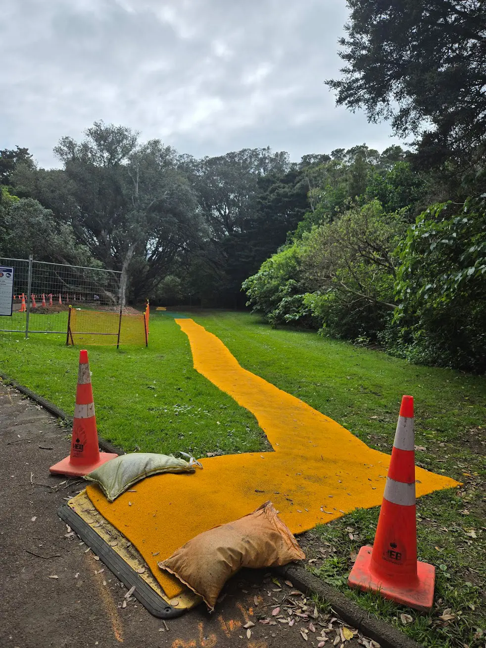 safe path matting on a construction site over grass with two construction cones at the entry points