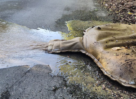 Filled and used large dewatering bag with water coming out.