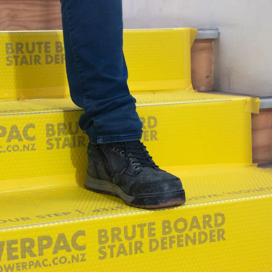 close up of brute board stair defender installed on stairs while person is walking down the stairs